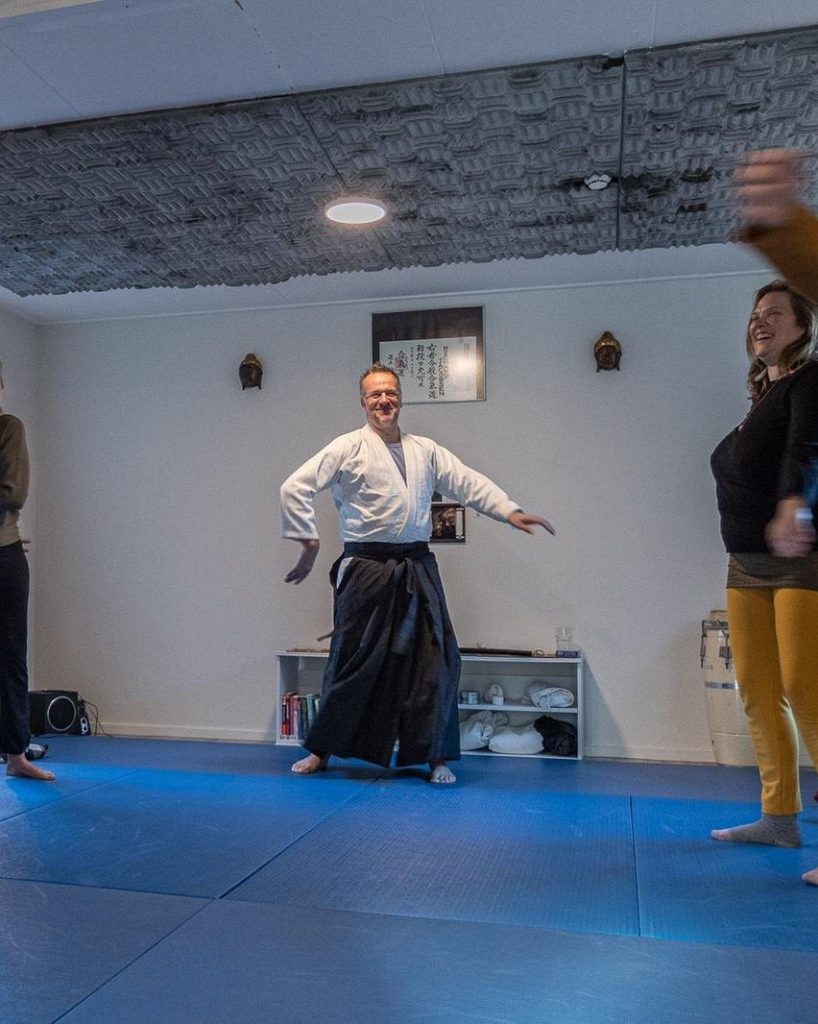 Richard Jacobsen laughing as he practises with a group on the mat