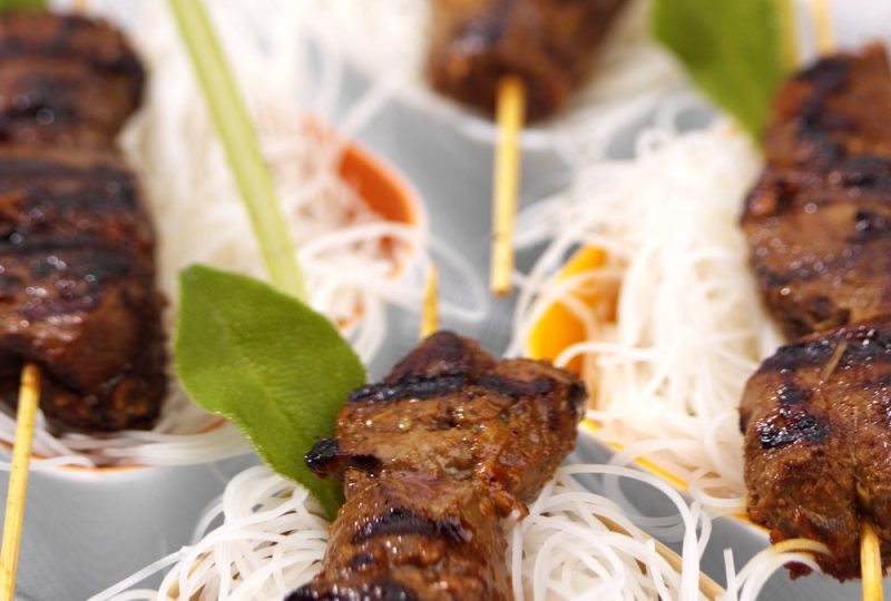 Grilled satay skewers on rice noodles with lemongrass