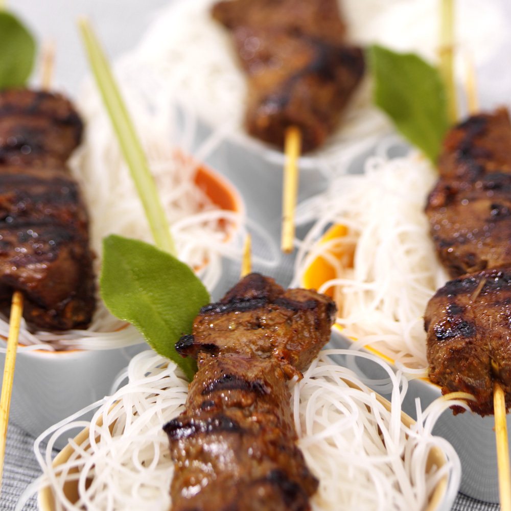 Grilled satay skewers on rice noodles with lemongrass