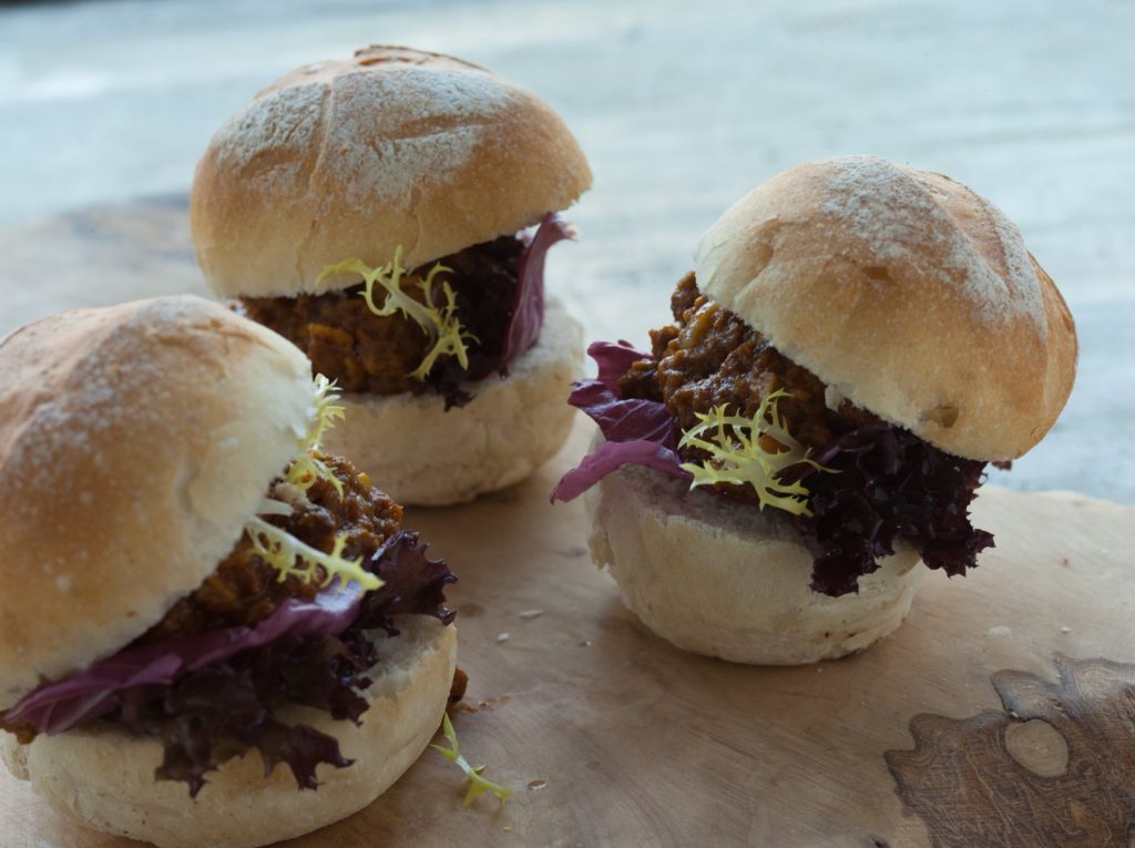 Rolls with braised beef, radicchio and frisée on a wooden board